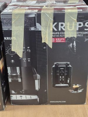 two boxes of krups coffee machines sitting on top of a wooden table
