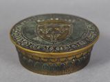 an antique brass box with a crest on the lid