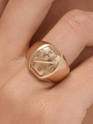 quelqu'un tient une bague en or sur laquelle est gravée la photo d'un homme