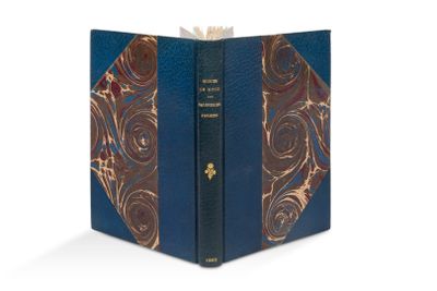 un livre ouvert dont la couverture est bleue et ornée de motifs dorés