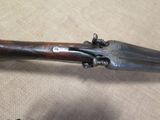 an old gun with a wooden handle on a table
