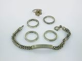 an assortment of silver rings and bracelets on a white surface