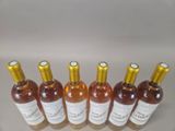 six bottles of wine are lined up in a row