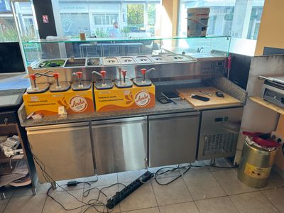 une photo de la cuisine d'un restaurant avec beaucoup de plats sur le comptoir