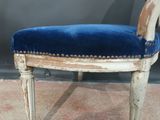 a chair with a blue velvet upholstered on it
