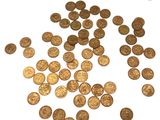 quelques pièces d'or sont éparpillées sur une surface blanche