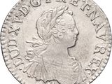 a silver coin with a woman ' s head on it