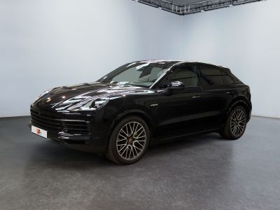 Une Porsche Cayenne noire est garée dans une grande pièce.