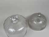 two glass containers with lids on a white surface