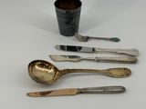 three spoons and a cup are sitting on a table