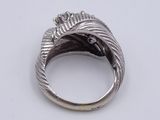 a close up of a ring on a white surface with a diamond