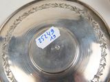 a silver plate with a sticker on it next to a spoon and spoon rest