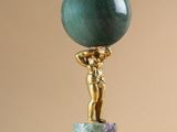 statue d'une femme tenant une boule de marbre verte posée sur un socle en marbre