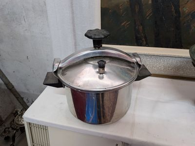 une casserole en argent posée sur un plan de travail blanc
