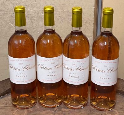 quatre bouteilles de vin sont alignées sur un tonneau en bois