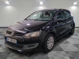 the black volkswagen polo is parked on a checkered tile floor