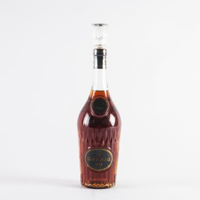 an empty bottle of brandy sitting on a white surface