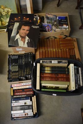 many books on the floor next to a box of cigarettes