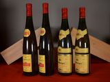 four bottles of wine are lined up on a table