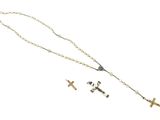 colliers avec chapelet et croix posés sur une surface blanche, sur fond blanc