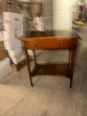 a small table with a drawer on it in a room
