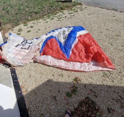 a young boy that is laying on the ground with a parachute