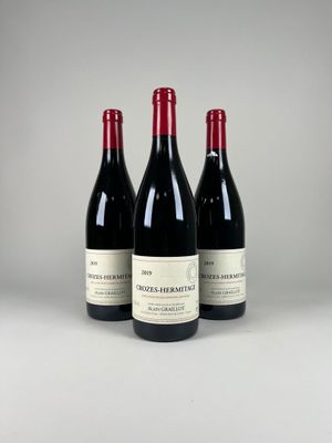 three bottles of red wine sitting next to each other on a table