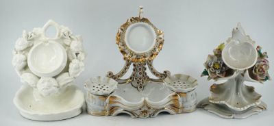 trois figurines en porcelaine assises les unes à côté des autres sur une table