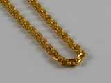 a close up of a gold chain on a white surface