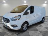 une fourgonnette Ford Transit blanche garée dans une pièce au sol carrelé