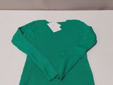 a green sweater sitting on top of a white table