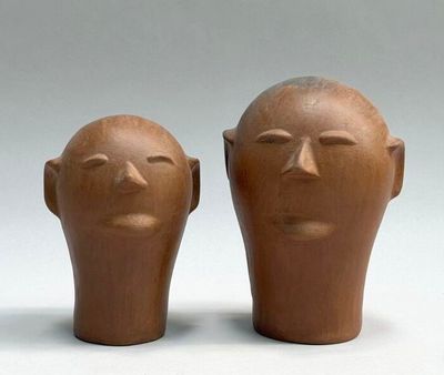 two clay heads sitting next to each other on a table