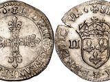 a silver coin with a crown on the front and a shield on the back