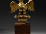 an image of a golden eagle statue on a wooden base