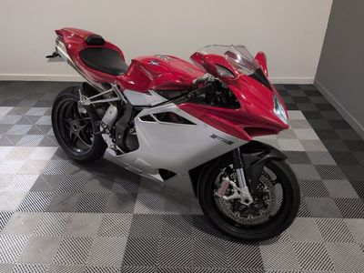 une moto rouge et blanche garée sur un sol à damier