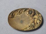 une plaque ancienne en laiton ornée de fleurs et de feuilles