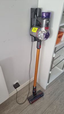 un aspirateur posé par terre à côté des toilettes