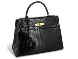 a black crocodile skin handbag with gold hardware