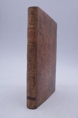un vieux livre posé sur une surface blanche
