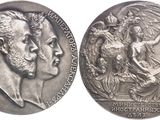 two silver medals with a man and a woman on them