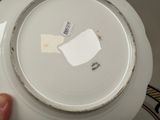 someone is holding a plate with a piece of paper on it