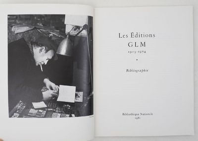Quelqu'un tient un livre sur lequel figure la photo en noir et blanc d'un homme assis à un bureau.