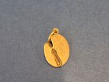 a close up of a gold charm with a bird on it