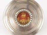 a silver plate with a picture of a sun on it