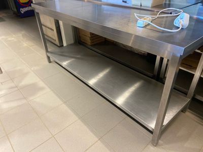 une grande table en acier inoxydable sur laquelle se trouve un cordon d'alimentation