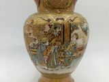 a vase with a painting on it sitting on a table