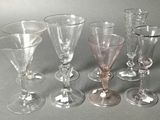 six wine glasses sitting next to each other on a table