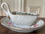 a white bowl and saucer with a spoon on a wooden table