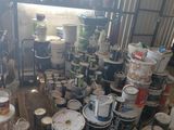 many cans of paint sitting on the floor in a room