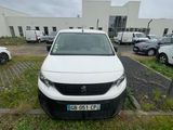 la camionnette blanche est garée dans un parking avec d'autres voitures